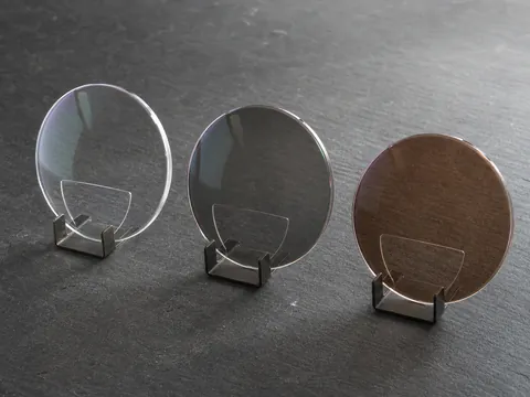 Clear grey and brown 1.56 photochromic flat-top bifocal HMC lens states on display stands