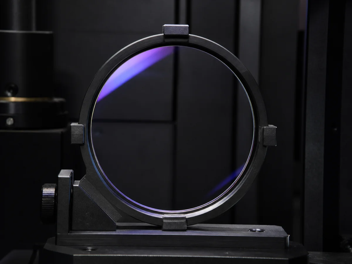 UV420 blue-filter optical lens positioned for transmission and coating inspection