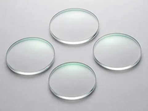 Clear 1.499 CR-39 HMC single-vision lens blanks with subtle green anti-reflective reflections
